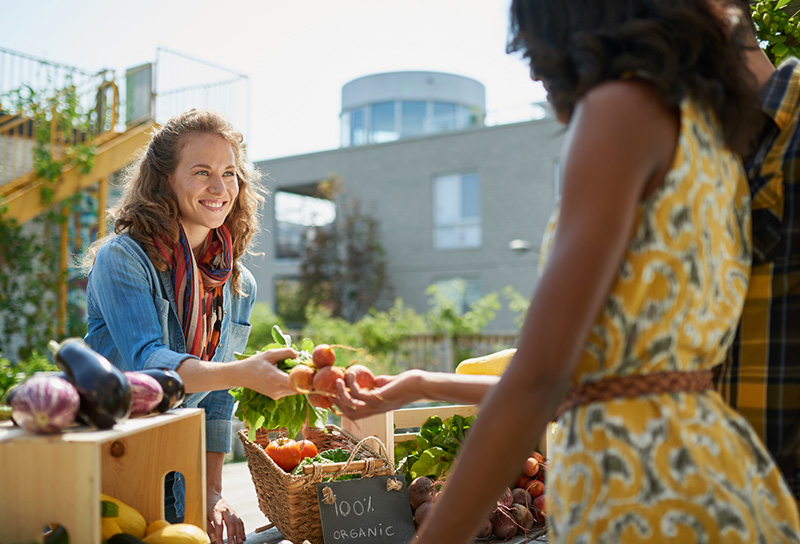 Women exchanging goods at a farmer's market